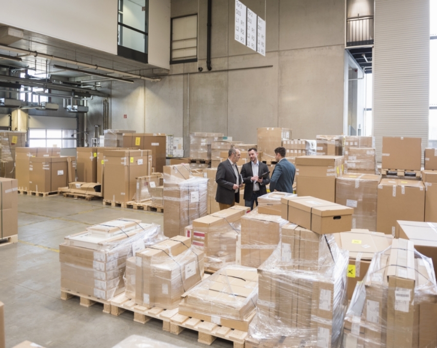 three-men-in-factory-warehouse-surrounded-by-cardb-2024-09-22-10-57-02-utc-1